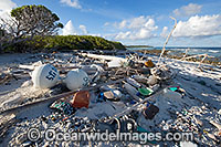 Marine pollution rubbish trash garbage comprising of plastic bottles, footwear and fishing implements washed ashore by tidal movement on a remote tropical island beach - probably drifting in from Indonesia. Cocos (Keeling) Islands, Indian Ocean, Australia