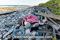 Marine pollution rubbish trash garbage comprising of plastic bottles, footwear, timber and fishing implements, washed ashore by tidal movement on a remote beach - probably drifting in from Indonesia. Cocos (Keeling) Islands, Indian Ocean, Australia.