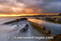 Sawtell Rock Pool at sunset during stormy weather. A favourite natural rock swimming pool open to the general public. Sawtell, New South Wales, Australia.