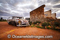 Abandoned old car beside the historic remnants of a Miners Cottage in the outback town of Silverton, near Broken Hill, New South Wales, Australia.