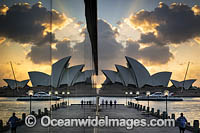 Sydney Opera House during sunrise, reflected on a building glass window. Sydney, New South Wales, Australia.