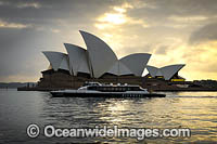 Public transport ferry passing by the Sydney Opera House during sunrise. Sydney, New South Wales, Australia.