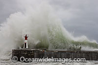 Huge wave breaking against harbor wall during a storm. Kalk Bay, Cape Town, South Africa