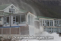 Waves breaking against a coastal house and property during a storm. Cape Town, South Africa