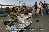 Women sell their catch on the beach at a fish market in Bali, Indonesia.