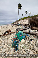 Marine pollution rubbish trash garbage comprising of plastic bottles, footwear and fishing implements, washed ashore by tidal movement on a remote tropical island beach. Cocos (Keeling) Islands, Indian Ocean, Australia