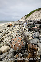 Marine pollution rubbish trash garbage comprising of plastic bottles, footwear and fishing implements, washed ashore by tidal movement on a remote tropical island beach. Cocos (Keeling) Islands, Indian Ocean, Australia