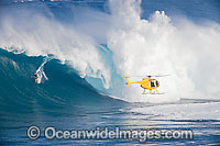 A helicopter filming a tow-in surfer at Peahi (Jaws) off Maui. Hawaii, Pacific Ocean.