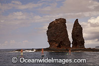 Three young people on stand-up paddle boards at Needles off the island of Lanai, Hawaii.