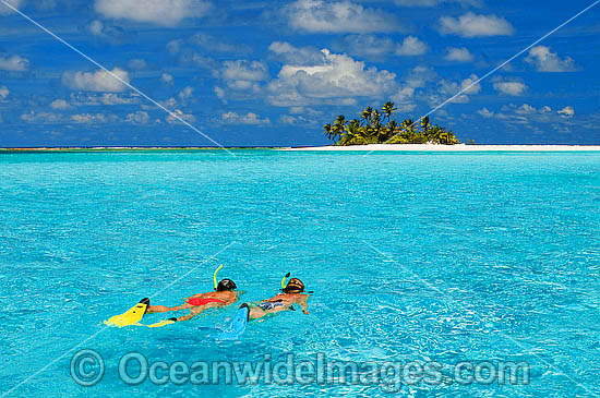  clear lagoon water surrounding a tropical coconut palm fringed island