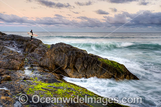 A Surfer with board under arm, prepares to enter the surf from a rocky coastal headland, situated at Sawtell, near Coffs Harbour, New South Wales, Australia. Photo - Gary Bell A Surfer with board under arm, prepares to enter the surf from a rocky coastal headland, situated at Sawtell, near Coffs Harbour, New South Wales, Australia. Photo - Gary Bell