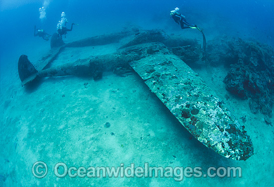 Scuba divers observing a Lockheed P-38 Lightning World War II American fighter aircraft, resting intact on the sea floor in Milne Bay, Papua New Guinea. Within the Coral Triangle. Photo - Bob Halstead Scuba divers observing a Lockheed P-38 Lightning World War II American fighter aircraft, resting intact on the sea floor in Milne Bay, Papua New Guinea. Within the Coral Triangle. Photo - Bob Halstead