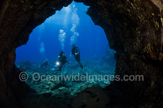 Scuba Divers explore the entrance to a lava tube off the Island of Lanai, Hawaii, Pacific Ocean. Photo - David Fleetham Scuba Divers explore the entrance to a lava tube off the Island of Lanai, Hawaii, Pacific Ocean. Photo - David Fleetham