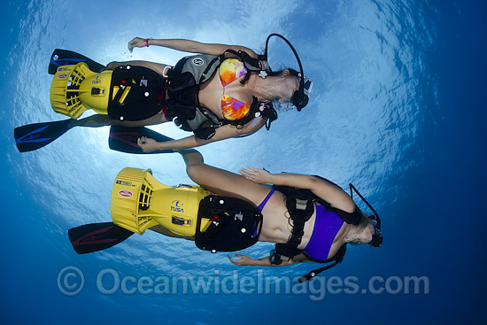 Scuba Divers exploring a tropical coral reef with underwater scooters in the waters of Hawaii, Pacific Ocean. Photo - David Fleetham Scuba Divers exploring a tropical coral reef with underwater scooters in the waters of Hawaii, Pacific Ocean. Photo - David Fleetham