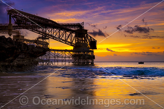 Sunset at Isabel Beach, with the phosphate loading wharf silhouetted in the foreground and Flying Fish Cove in distant background. Christmas Island, Indian Ocean, Australia. Photo - Gary Bell