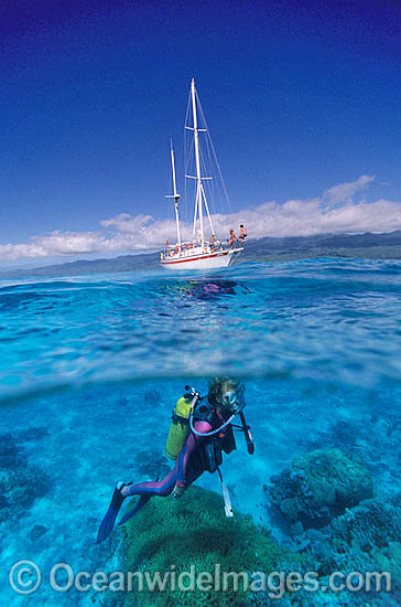 Scuba Diver beneath sailing yacht photo