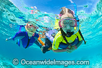 Children with parent snorkel diving on the Great Barrier Reef. Photo taken at Heron Island, Great Barrier Reef, Queensland, Australia.