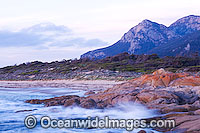 Salmon Rocks - Lichen (Caloplaca sp.) covered coastal granite boulders, with Strezlecki National Park granite peaks in background. Flinders Island, Tasmania, Australia