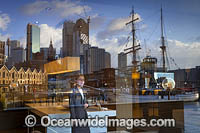 Reflection on building glass window showing Tall Ship 