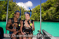 Divers (MR) in scuba gear about to enter the water off a boat in The Rock Islands, Palau, Micronesia.