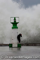 Wave breaking over lighthouse Photo - Chris and Monique Fallows